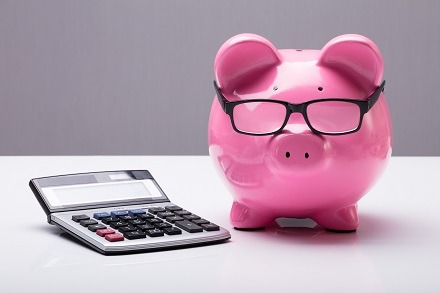 Piggy bank with glasses and calculator for calculating tax